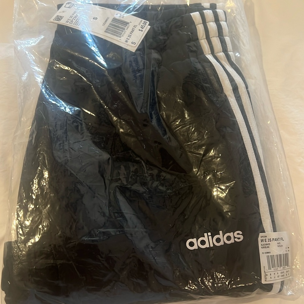 ADIDAS Black elastic waist joggers with white side stripes.